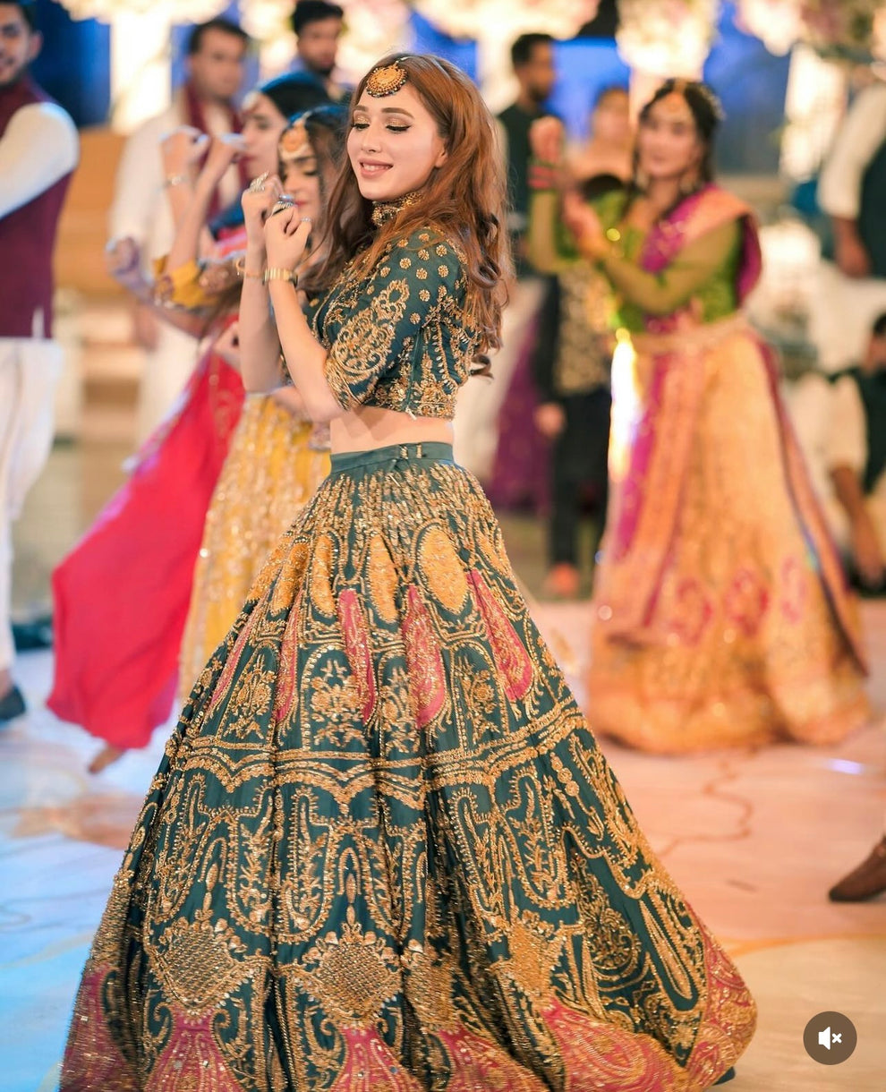 Detailed view of antique gold embroidery and mustard red paisley motifs on Ahmad Sultan Suraz lehenga