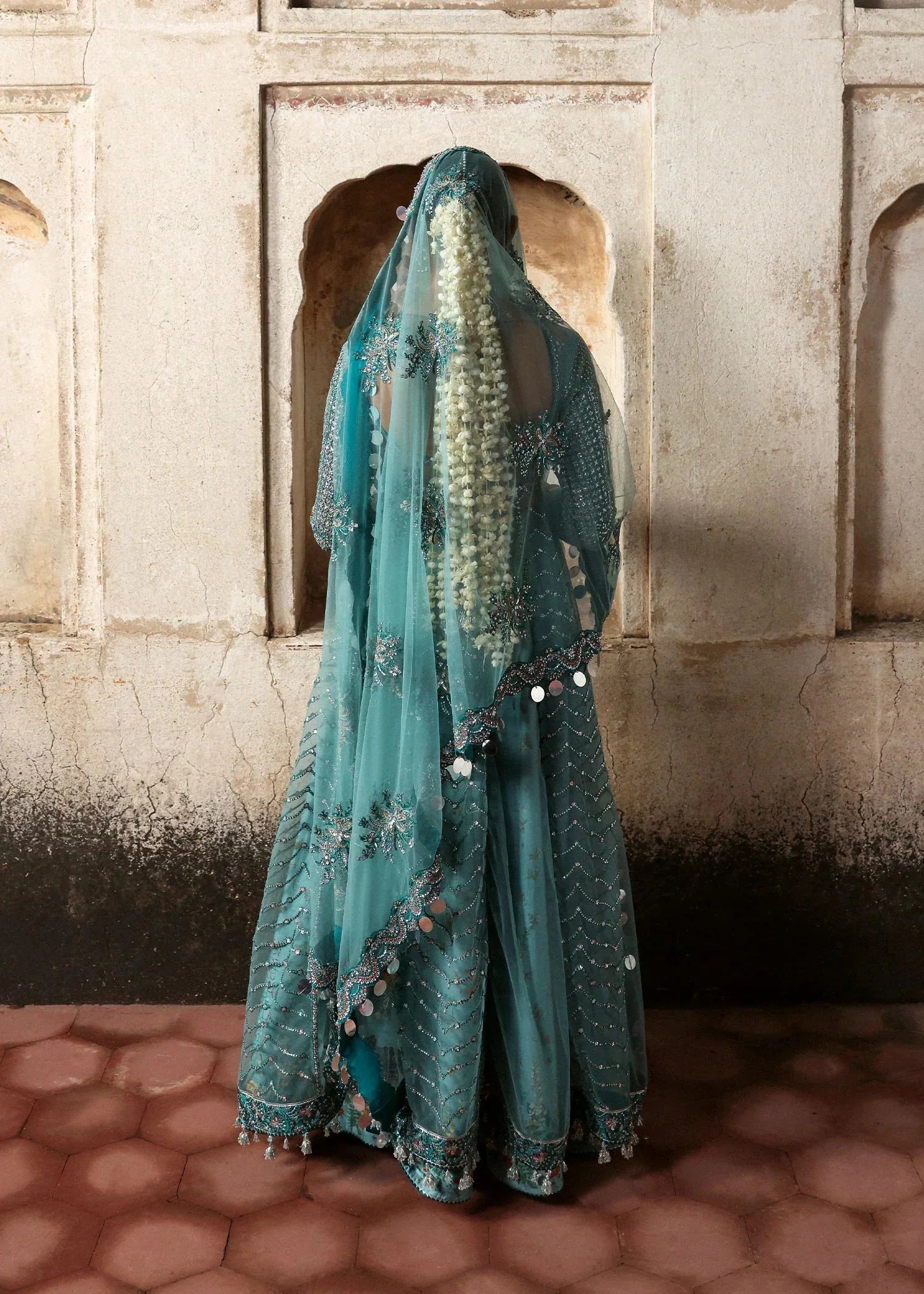 Hussain Rehar Nagma teal net pishwas featuring intricate embroidered bodice and embellished sheer neckline at Zenni’s Atelier