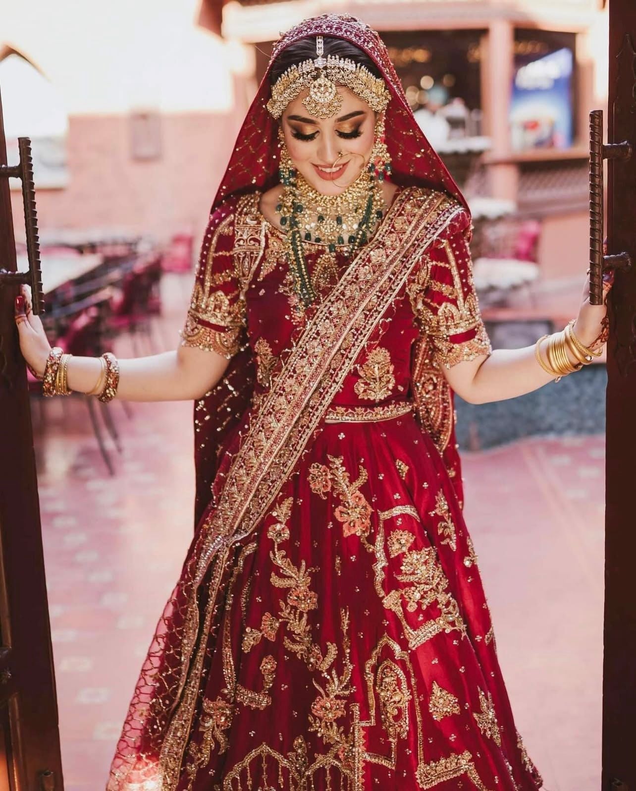 Mohsin Naveed Ranjha maroon bridal outfit featuring intricate antique gold embroidery at Zenni’s Atelier